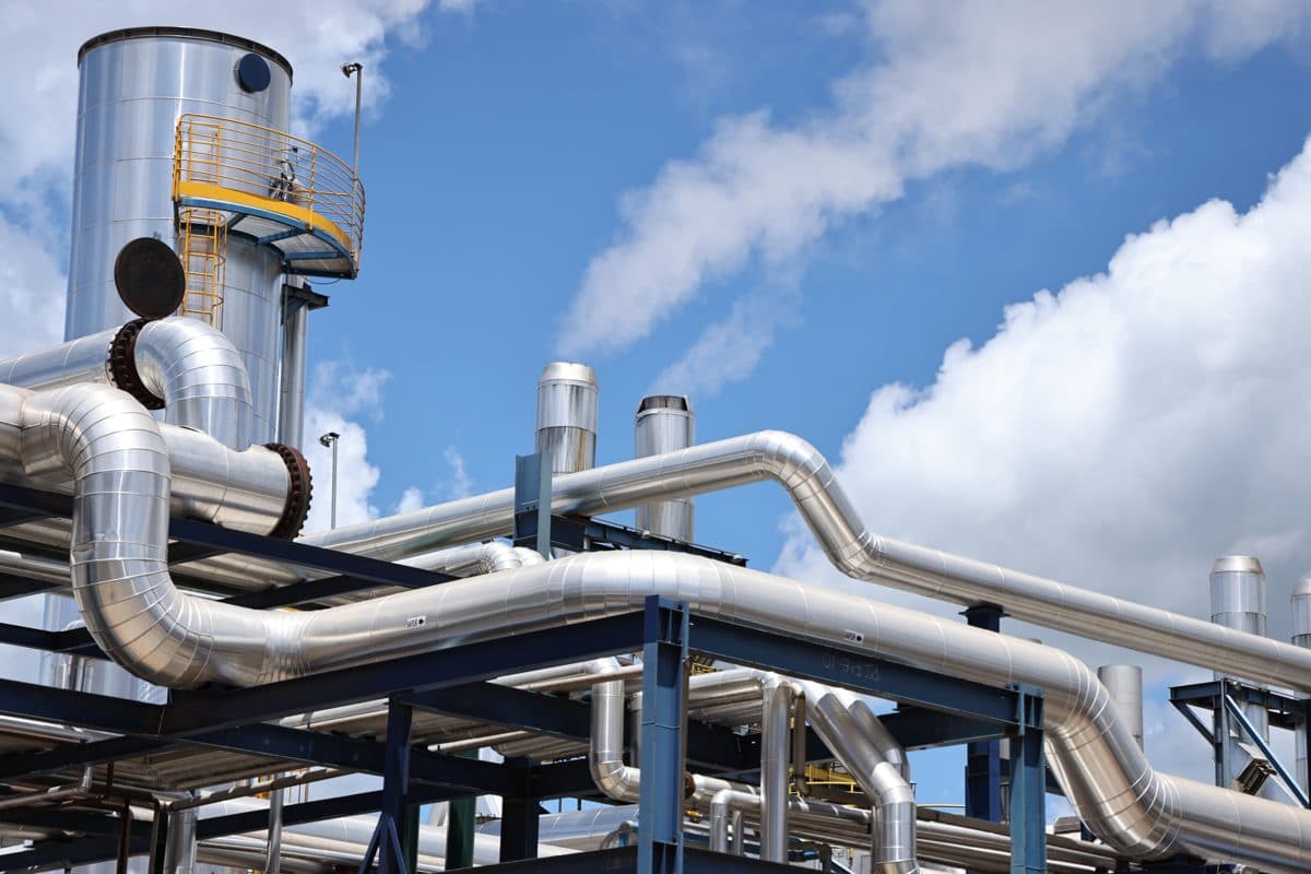 Tubulações e tanque de uma unidade industrial Inpasa sob céu azul